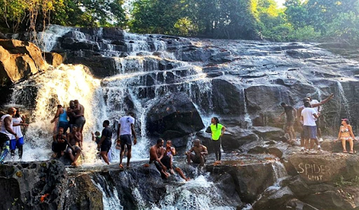 Individuals standing in a waterfall in Sierra Leone