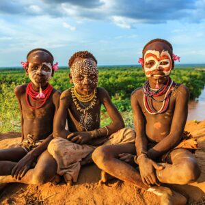 Three children donning traditional African attire and face paint
