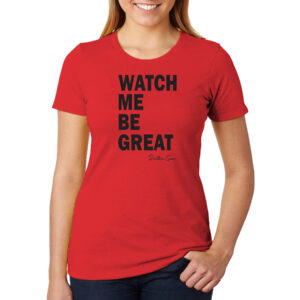 A woman wearing a red shirt that reads in black bold text, "Watch me be great"